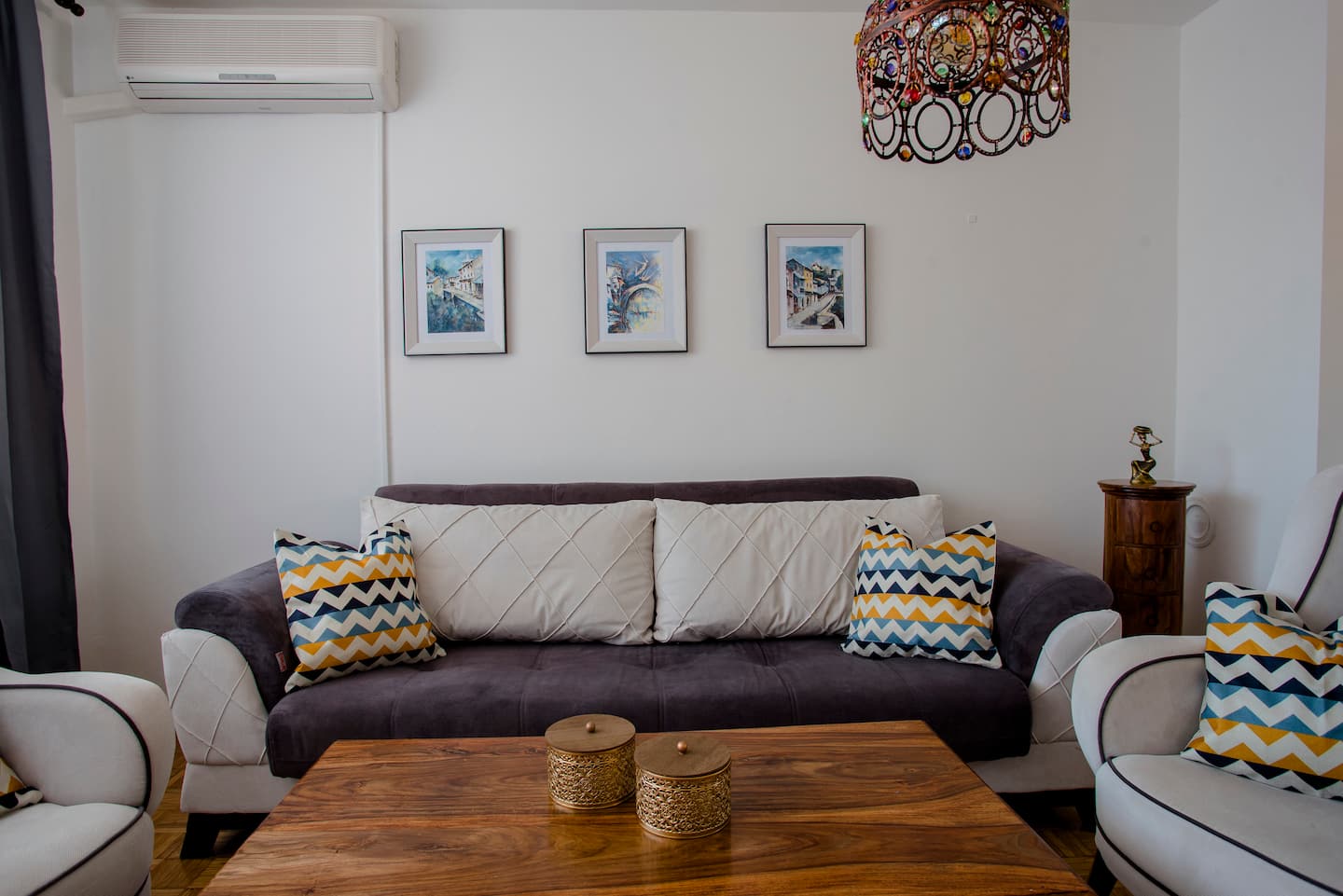 Seating area with framed prints on the wall and air conditioning unit above